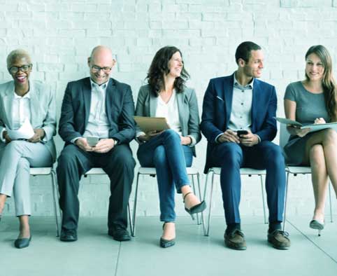 group of people sitting in a row in chairs